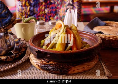 Tagine, alias Tajine, tradizionale piatto di verdure al vapore, teiera e pane in un elegante ristorante a Marrakech, Marocco, 15 dicembre 2023 Foto Stock