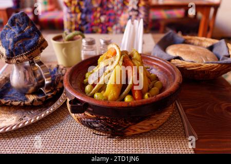 Tagine, alias Tajine, tradizionale piatto di verdure al vapore, teiera e pane in un elegante ristorante a Marrakech, Marocco, 15 dicembre 2023 Foto Stock