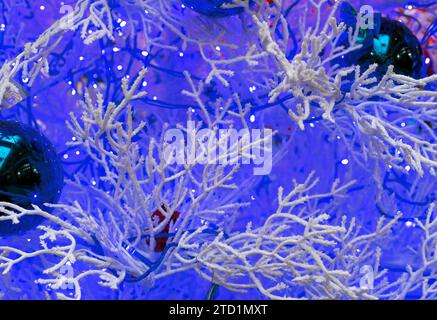 Sfondo natalizio con rami innevati e ghirlanda blu. Foto Stock