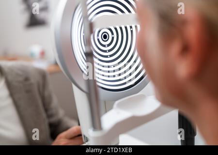 Primo piano di un paziente sottoposto a un esame oculistico con un cheratografo o un phoropter in una clinica. Foto Stock