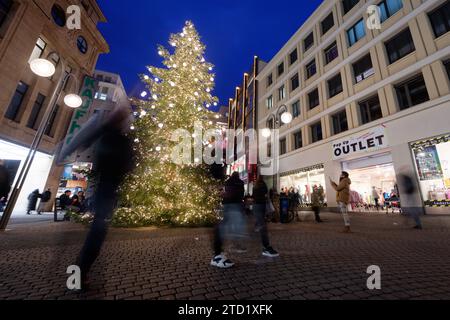 PRODUZIONE - 15 dicembre 2023, Renania settentrionale-Vestfalia, Colonia: Un albero di Natale si trova nella zona pedonale di Schildergasse. Foto: Henning Kaiser/dpa - ATTENZIONE: Utilizzare solo in formato completo Foto Stock
