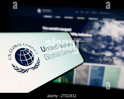 Telefono cellulare con logo del patto ONU Global Compact delle Nazioni Unite davanti al sito web. Mettere a fuoco sul lato sinistro del display del telefono. Foto Stock