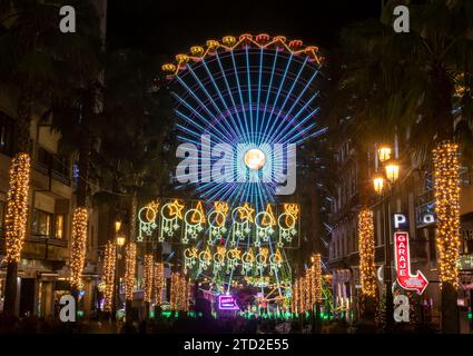 Vigo, Spagna - 10 dicembre 2023: Luci natalizie su Colon Street nel centro della città di Vigo, in Spagna, con la grande ruota panoramica di Natale. Foto Stock