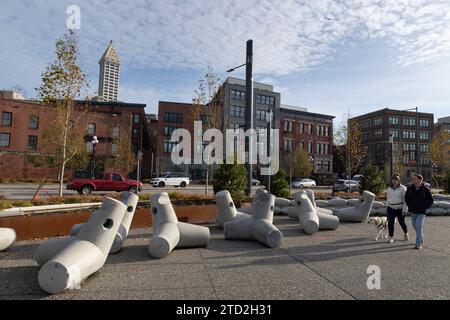 Seattle, Washington, USA. 12 dicembre 2023. Un paio di passeggiate lungo il lungomare dell'Alaska Way passando per 'Dolos antropomorfi' dell'artista Buster Simpson. Il progetto di riqualificazione del lungomare di Seattle, che include una passeggiata sul lungomare del parco, piste ciclabili e nuove piazze pubbliche, dovrebbe essere completato nel 2025. Credito: Paul Christian Gordon/Alamy Live News Foto Stock