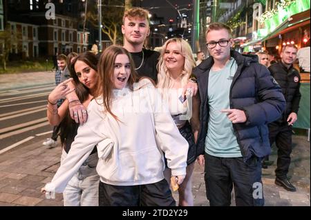 Broad Street, Birmingham 16 dicembre 2023 - venerdì 15 dicembre sera i venditori hanno visitato la famigerata striscia di nightclub di Birmingham, mentre si sono divertiti dal secondo all'ultimo venerdì prima di Natale. Diversi festaioli indossavano abiti natalizi e una festa di lavoro piena di Santas posero per una foto di gruppo prima di recarsi in un altro pub. Gli amici si portavano l'un l'altro lungo la zona della vita notturna di Broad Street mentre la sera si trasformava in mattina. Altri sono stati visti in abiti eleganti dopo aver frequentato i galà festivi del centro città. Molte persone hanno mostrato i loro Jumpers natalizi mentre godevano di temperature miti. La Foto Stock