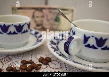 Bitter Brew: Tazze di caffè, chicchi costosi e una banconota da cinque dollari Foto Stock