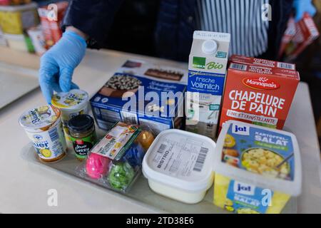 PRODUZIONE - 15 dicembre 2023, Renania settentrionale-Vestfalia, Oberhausen: Le persone bisognose ricevono cibo dalla banca alimentare. Le code davanti ai punti di distribuzione della banca alimentare, i volontari al limite della loro capacità e la domanda di cibo in continua crescita: Il sostegno a più di 600.000 persone bisognose in NRW sta raggiungendo i suoi limiti. Foto: Rolf Vennenbernd/dpa Foto Stock