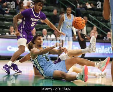 Tulane Green Wave Forward Collin Holloway (5) passa la palla mentre è seduto sul pavimento mentre è difeso dall'attaccante dei Furman Paladins Tyrese Hughey (15) durante una partita di basket maschile alla Fogleman Arena di New Orleans, Louisiana, giovedì 14 dicembre 2023. (Foto di Peter G. Forest/Sipa USA) Foto Stock