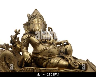 foto ravvicinata della statua decorata del signore ganesh della mitologia indù scolpita in ottone dorato isolato su sfondo bianco Foto Stock