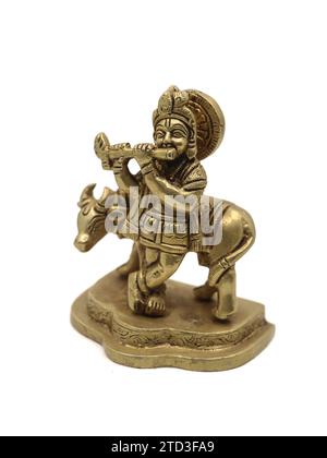 statua vintage del signore krishna che suona musica flauto accanto a una mucca, un avatar vishnu isolato in uno sfondo bianco Foto Stock