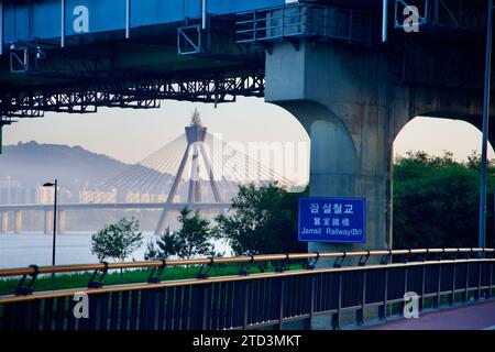 Seul, Corea del Sud - 2 giugno 2023: Vista mattutina del ponte ferroviario di Jamsil che incornicia il ponte olimpico sul fiume Han, con una nebbiosa alba sul retro Foto Stock