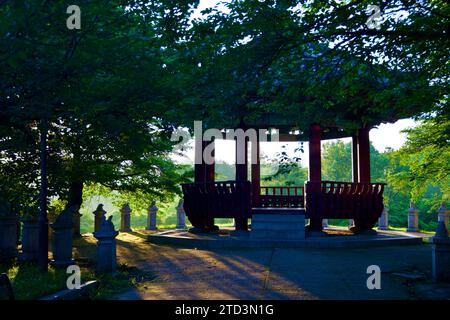 Seoul, Corea del Sud - 2 giugno 2023: Un padiglione ottagonale all'interno del Parco Olimpico crea una silhouette suggestiva contro il sole del mattino presto e i dintorni Foto Stock