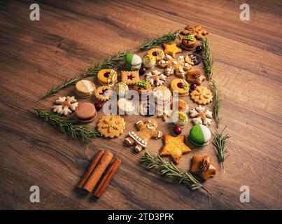 Biscotti di Natale assortiti a forma di albero di Natale su sfondo di legno. Foto Stock