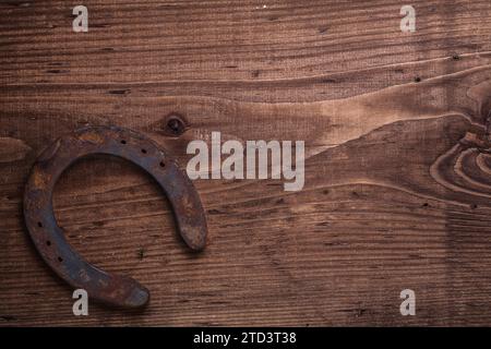 Ferro di cavallo arrugginito vecchio stile su tavola di legno d'epoca Foto Stock