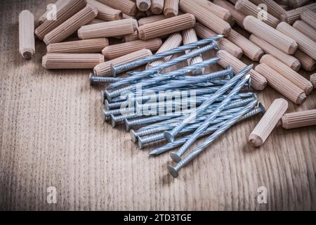 Pila di tasselli in legno che costruiscono chiodi su sfondo in legno Foto Stock