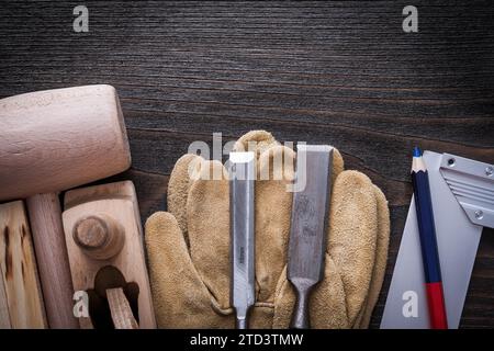 Composizione di utensili e guanti in pelle carpenterÐ²Ð‚â„¢su tavola in legno vintage concetto di costruzione Foto Stock