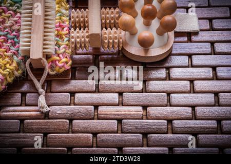 Soffice scrubber per il corpo spazzola esfoliante in legno e massaggiatori con materasso quadrato in legno testurizzato e sauna Foto Stock