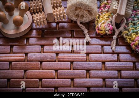 Morbido massaggiatore esfoliante in legno e loofah sul concetto di sauna con tappetino quadrato in legno a scacchi Foto Stock