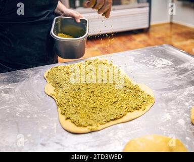 Preparazione e preparazione di dolci fatti in casa al pistacchio babka, pane dolce. Brioche a pasta naturale di Cozonac. Foto Stock