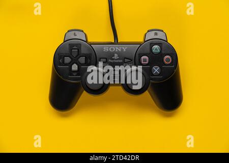 Controller della console PlayStation per PS2 di Sony davanti a uno sfondo giallo monocromatico, vista dall'alto Foto Stock