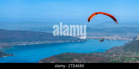 Parapendio sopra il lago di Annecy, in autunno, in alta Savoia, Francia Foto Stock