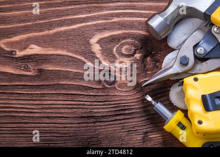 Martello a baionetta guanto protettivo cacciavite a taglio e pinze su tavola di legno Foto Stock