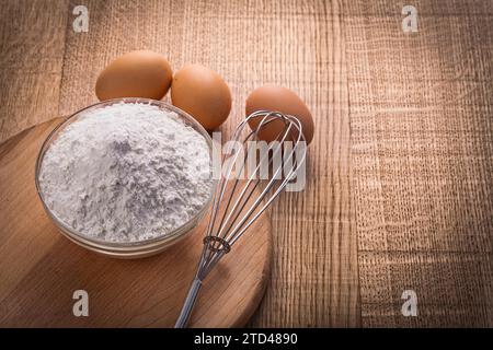 Farina nel recipiente uova di corolla su tavola di legno concetto di cibo e bevande Foto Stock