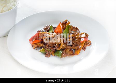 Piatto tipico cinese, mescola di manzo fresco fritto con germogli di bambù e funghi di pepe, fotografia gastronomica Foto Stock