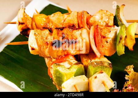 Spiedini di pollo e verdure freschi su foglie di palma in stile thailandese, fotografie gastronomiche Foto Stock