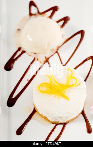 Dessert molto elegante con mousse di limone servito con buccia di limone e gelato alla vaniglia a lato, CIBO PIÙ DELIZIOSO IN PORTAFOGLIO, fotografia gastronomica Foto Stock