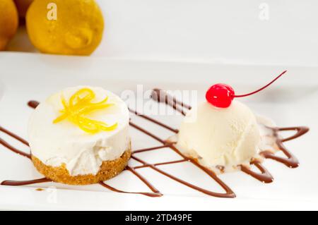 Dessert molto elegante con mousse di limone servito con buccia di limone e gelato alla vaniglia a lato, CIBO PIÙ DELIZIOSO IN PORTAFOGLIO, fotografia gastronomica Foto Stock