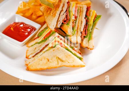 Club sandwich a tre piani con patatine fritte e fotografie di cibo Foto Stock