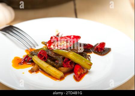 Peperoncino fritto e verdure su una teglia wok Foto Stock