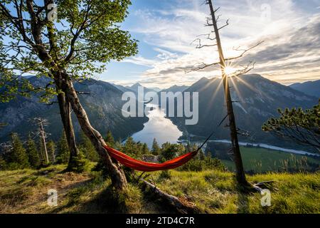 Vista di Plansee da Schoenjoechl con amaca arancione, al tramonto, stella del sole, vista panoramica delle montagne con il lago, Plansee, Tirolo, Austria Foto Stock