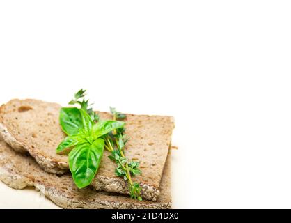 Pane rustico italiano, basilico e timo, semplice spuntino su un tavolo di legno bianco Foto Stock