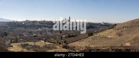 Vista panoramica della storica città di Segovia, Spagna, con edifici prominenti contro un cielo limpido, circondati da un paesaggio naturale. Foto Stock