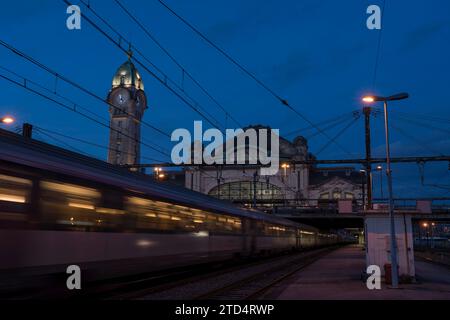 Il treno passa davanti alla Gare des Benedictins al crepuscolo, Limoges, Winter, France Foto Stock