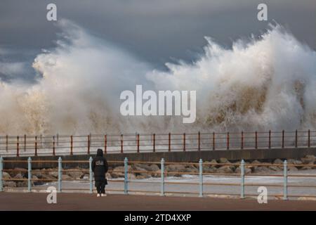 Grosvenor Breakwater, Heysham, Lancashire, 16 dicembre 2023, Walker osserva le onde che si infrangono sul Grosvenor Breakwater all'alta marea. Credito: PN News/Alamy Live News Foto Stock