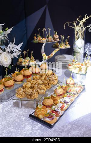 Croissant, hamburger e vari spuntini sui banchi del tavolo del buffet Foto Stock