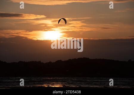 Gothenburg, Svezia - 10 2021 ottobre: Kiteboarders kitesurf al tramonto in una spiaggia. Foto Stock