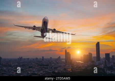 Aereo commerciale che sorvola la città con i grattacieli all'ora d'oro del tramonto Foto Stock