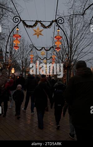 Luci natalizie sospese lungo uno degli ampi sentieri dei Giardini di Tivoli. Fa parte del Julemarked (mercato di Natale) a Copenh Foto Stock