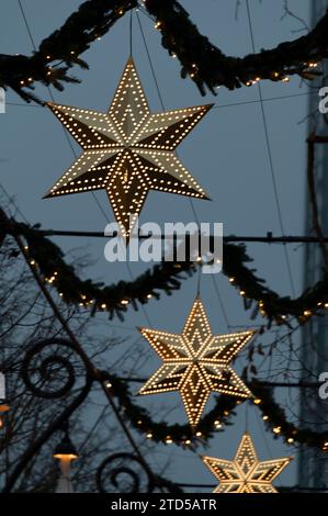 Luci natalizie sospese lungo uno degli ampi sentieri dei Giardini di Tivoli. Fa parte del Julemarked (mercato di Natale) a Copenh Foto Stock