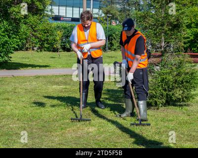 Murmansk, Russia - 09 agosto 2021: Gli scolari sistemano il prato durante la pratica estiva, Central Park Murmansk Foto Stock