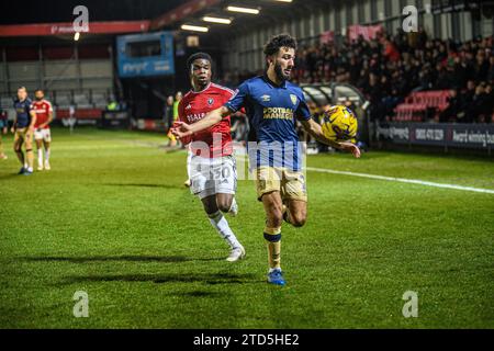 Salford, Regno Unito. 16 dicembre 2023.Huseyin Biler di Wimbledon cerca di bloccare Kelly N'mai di Salford City dal pallone durante la partita di Sky Bet League 2 tra Salford City e AFC Wimbledon a Moor Lane, Salford sabato 16 dicembre 2023. (Foto: Ian Charles | mi News) crediti: MI News & Sport /Alamy Live News Foto Stock