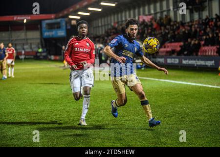 Salford, Regno Unito. 16 dicembre 2023.Huseyin Biler di Wimbledon cerca di bloccare Kelly N'mai di Salford City dal pallone durante la partita di Sky Bet League 2 tra Salford City e AFC Wimbledon a Moor Lane, Salford sabato 16 dicembre 2023. (Foto: Ian Charles | mi News) crediti: MI News & Sport /Alamy Live News Foto Stock