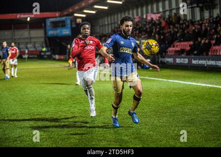 Salford, Regno Unito. 16 dicembre 2023.Huseyin Biler di Wimbledon cerca di bloccare Kelly N'mai di Salford City dal pallone durante la partita di Sky Bet League 2 tra Salford City e AFC Wimbledon a Moor Lane, Salford sabato 16 dicembre 2023. (Foto: Ian Charles | mi News) crediti: MI News & Sport /Alamy Live News Foto Stock