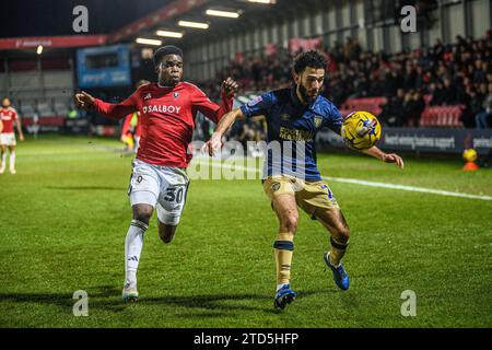 Salford, Regno Unito. 16 dicembre 2023.Huseyin Biler di Wimbledon cerca di bloccare Kelly N'mai di Salford City dal pallone durante la partita di Sky Bet League 2 tra Salford City e AFC Wimbledon a Moor Lane, Salford sabato 16 dicembre 2023. (Foto: Ian Charles | mi News) crediti: MI News & Sport /Alamy Live News Foto Stock