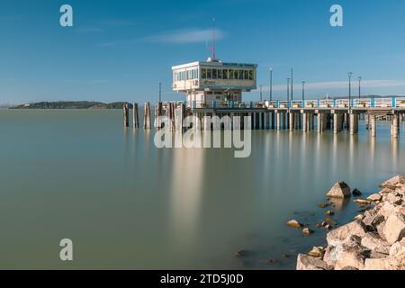 Villaggio collinare di Passignano che si riflette nel Lago Trasimeno, Umbria, Italia Foto Stock