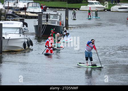 Gruppo di Sup Boarders all'evento natalizio di paddle boarding organizzato dai BH Activity Junkies. Sul fiume Stour a Christchurch, Dorset, Regno Unito Foto Stock